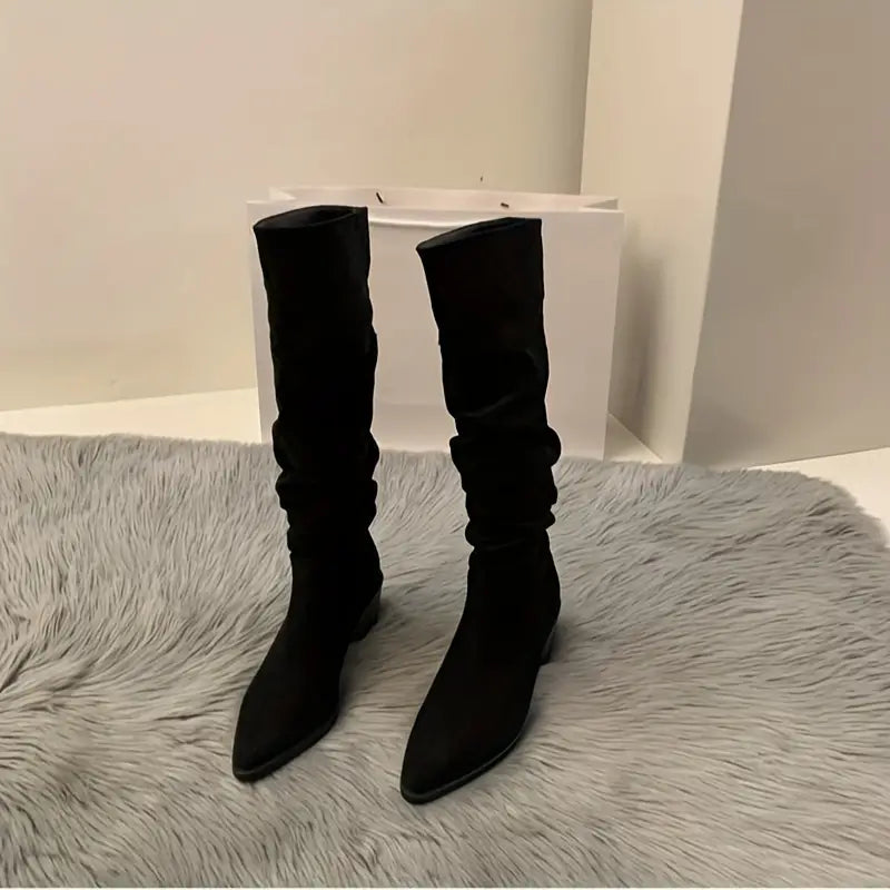 – Robuste, spitz zulaufende Stiefel, die bis zur Mitte der Wade reichen