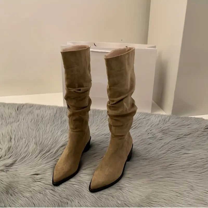 – Robuste, spitz zulaufende Stiefel, die bis zur Mitte der Wade reichen